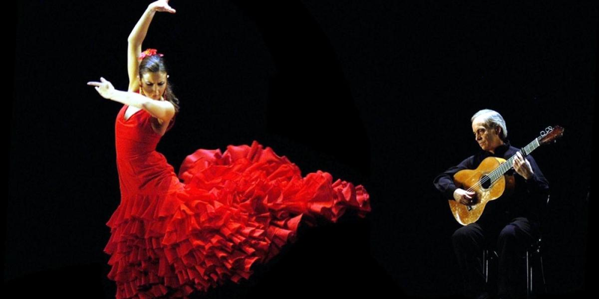 Una bailaora de flamenco junto a un guitarrista.