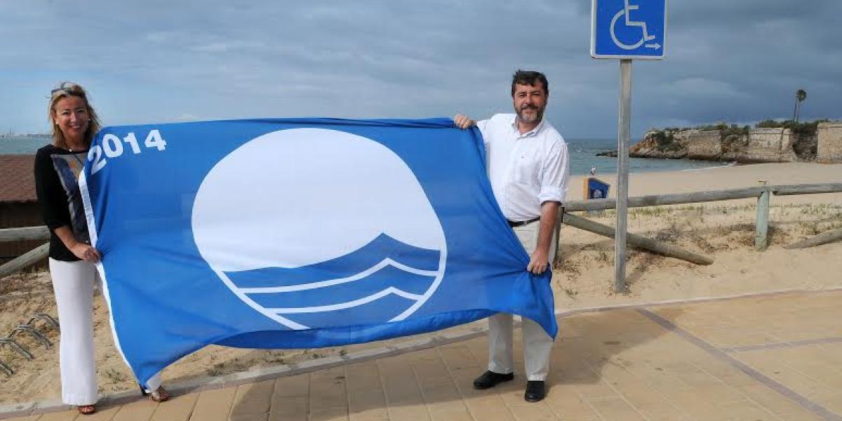 Marta Rodríguez y Alfonso Candón con una Bandera Azul.